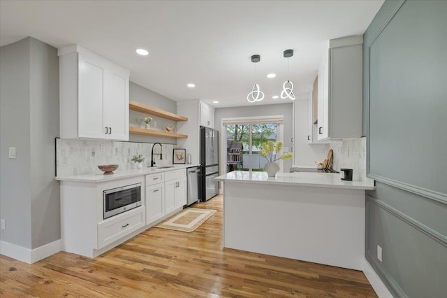 kitchen with stainless steel appliances, a sink, tasteful backsplash, open shelves, and recessed lighting