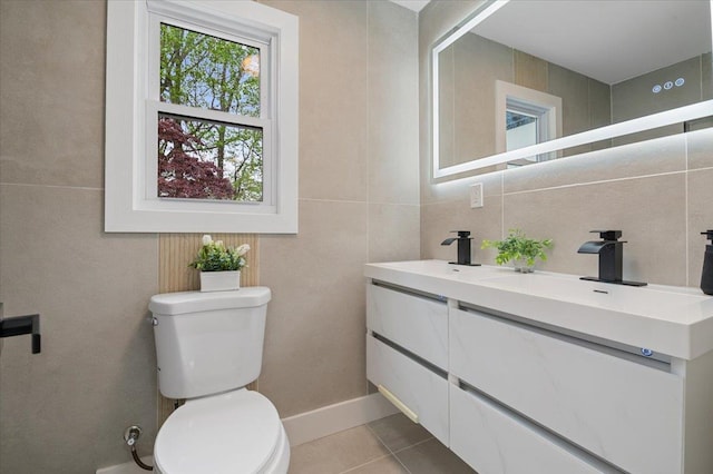 bathroom featuring tile walls, toilet, tile patterned flooring, and double vanity