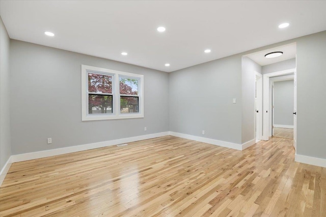 spare room featuring light wood finished floors, baseboards, and recessed lighting