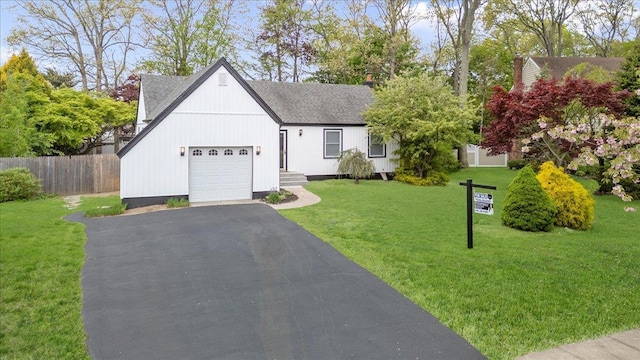 view of front of property featuring an attached garage, asphalt driveway, and roof with shingles