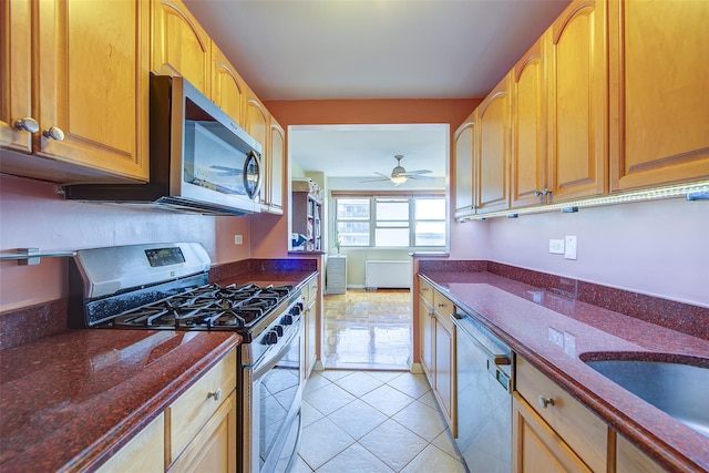 102-10 66th Rd Unit 26H, Forest Hills, NY 11375 - kitchen with appliances with stainless steel finishes, dark stone counters, light tile patterned flooring, a ceiling fan, and a sink