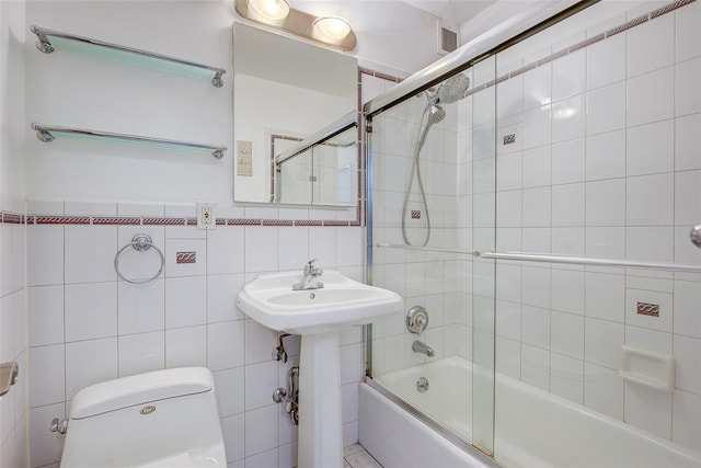 102-10 66th Rd Unit 26H, Forest Hills, NY 11375 - full bathroom with tile walls, toilet, shower / bath combination with glass door, and a sink