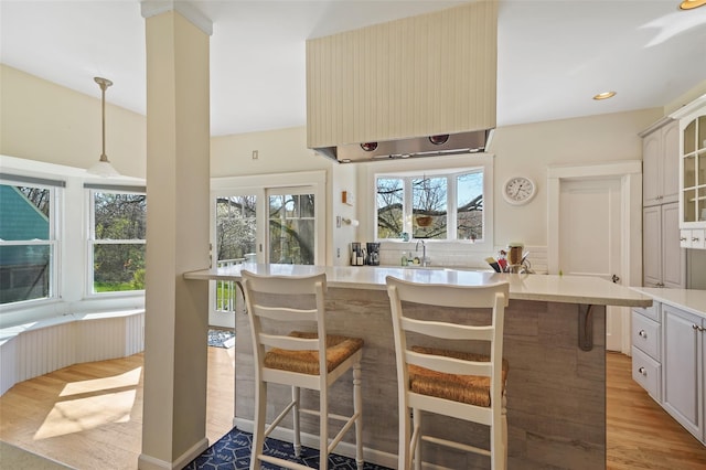 kitchen with a sink, light wood-style floors, light countertops, plenty of natural light, and recessed lighting