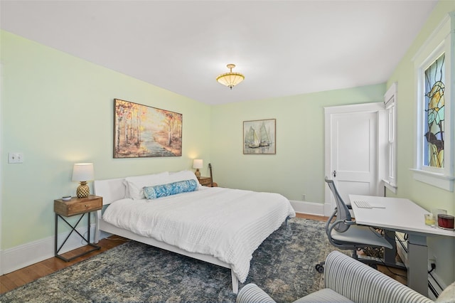 bedroom with wood finished floors and baseboards