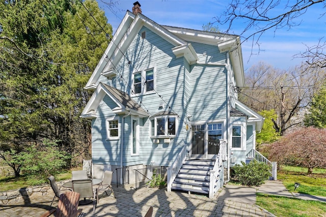 back of house featuring a patio area and a chimney