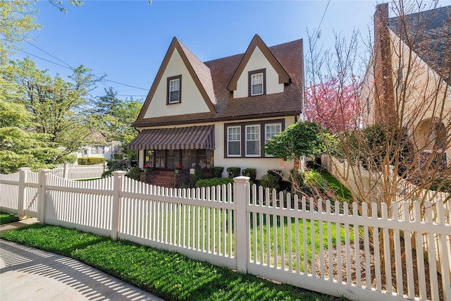 1875 Harte St, Baldwin, NY 11510 - tudor house featuring stucco siding, a fenced front yard, and roof with shingles