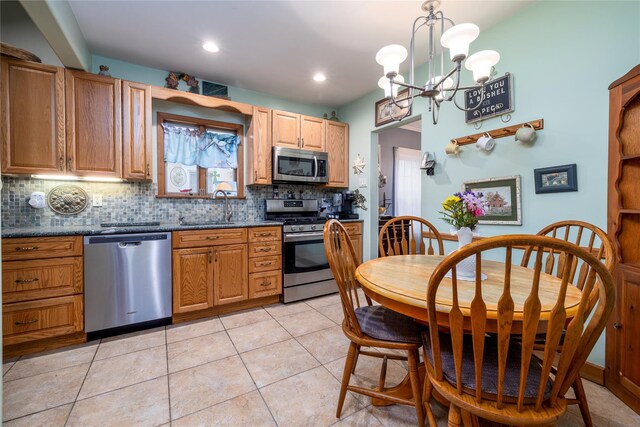 1875 Harte St, Baldwin, NY 11510 - kitchen featuring appliances with stainless steel finishes, a sink, dark countertops, tasteful backsplash, and a chandelier