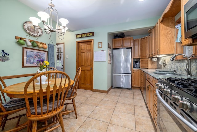 1875 Harte St, Baldwin, NY 11510 - kitchen featuring appliances with stainless steel finishes, a sink, a chandelier, decorative backsplash, and brown cabinetry