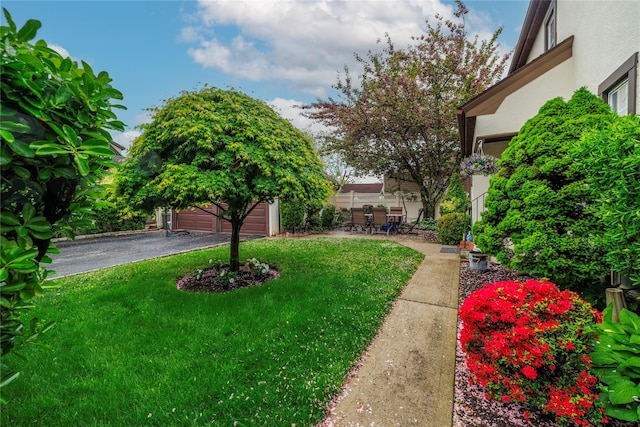 1875 Harte St, Baldwin, NY 11510 - view of green lawn with an outdoor structure, a garage, and a patio area