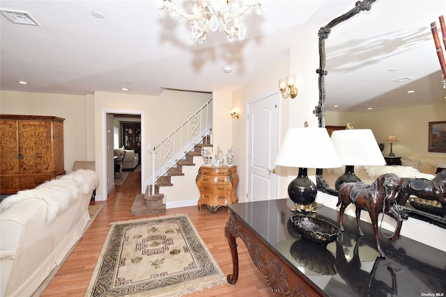 living area featuring stairs, light wood-style flooring, a chandelier, and recessed lighting