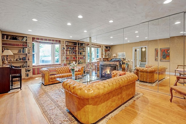 21 Hereford Rd, Great Neck, NY 11020 - living area featuring wood finished floors, a lit fireplace, healthy amount of natural light, recessed lighting, and built in features