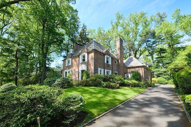 21 Hereford Rd, Great Neck, NY 11020 - view of front facade featuring a front yard and a chimney