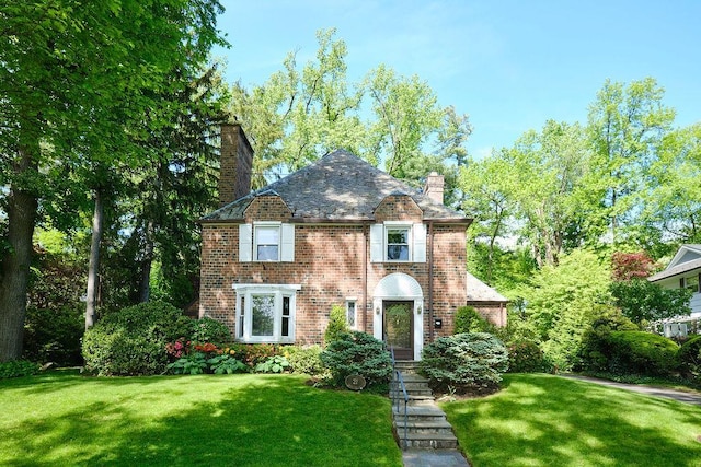 21 Hereford Rd, Great Neck, NY 11020 - view of front of property featuring a chimney, a high end roof, a front yard, and brick siding