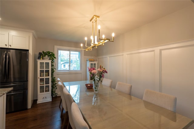 dining area with a decorative wall, a chandelier, dark wood-style floors, and wainscoting