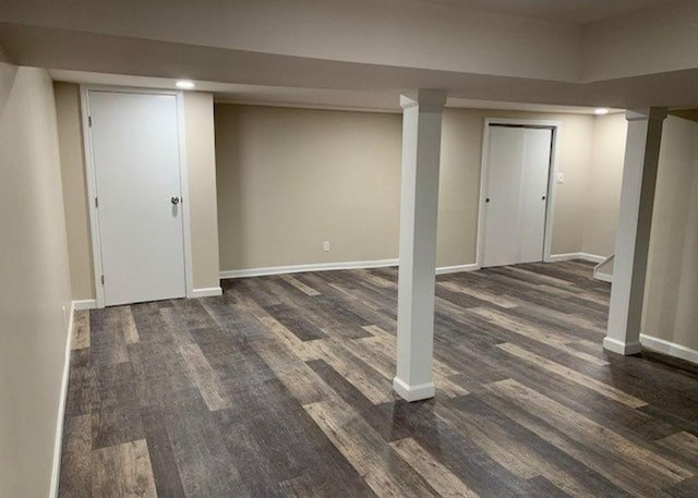 finished basement with dark wood-style flooring and baseboards