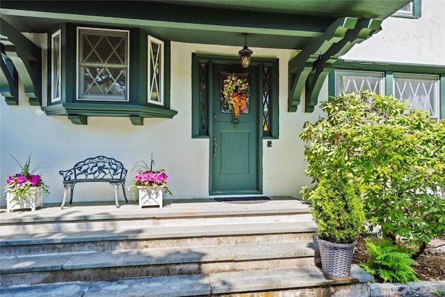17 The Intervale, Roslyn Estates, NY 11576 - view of exterior entry with stucco siding and covered porch