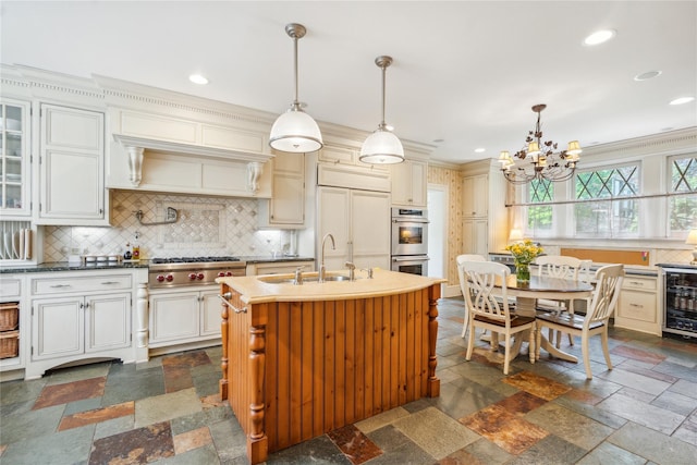 17 The Intervale, Roslyn Estates, NY 11576 - kitchen with a sink, beverage cooler, stainless steel appliances, a chandelier, and backsplash