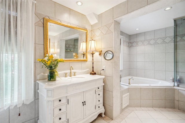 17 The Intervale, Roslyn Estates, NY 11576 - bathroom with tile walls, tiled tub, tile patterned floors, and vanity