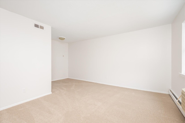 empty room with light carpet, baseboards, and baseboard heating