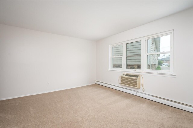 unfurnished room featuring carpet, a baseboard heating unit, an AC wall unit, and baseboards