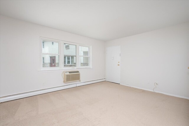 empty room with light carpet, an AC wall unit, a baseboard heating unit, and baseboards