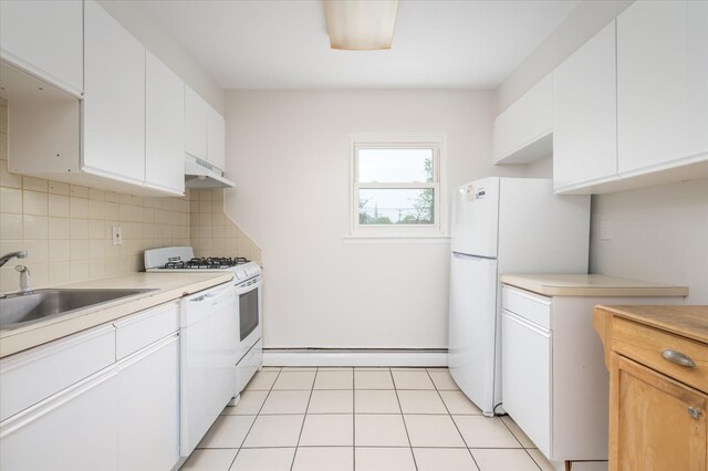 kitchen with baseboard heating, under cabinet range hood, white appliances, a sink, and light countertops
