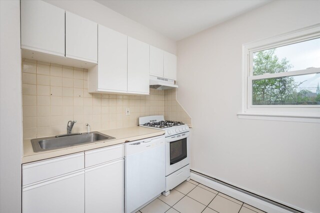 kitchen with white appliances, under cabinet range hood, a sink, a baseboard heating unit, and light countertops