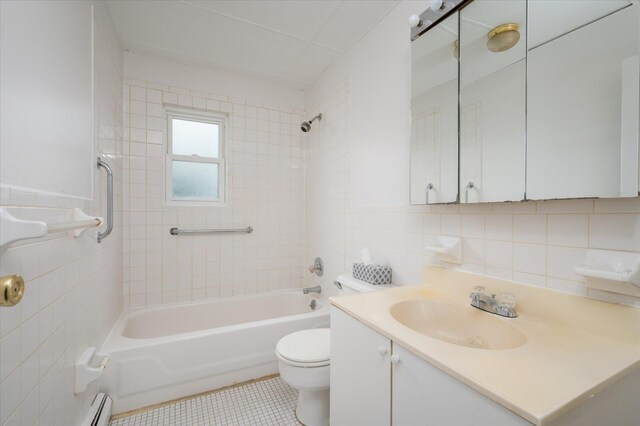 bathroom featuring tile walls, toilet, vanity,  shower combination, and tile patterned floors
