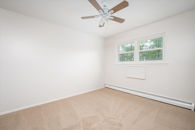 carpeted spare room with a baseboard radiator, baseboards, and ceiling fan