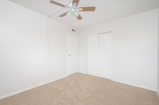 unfurnished bedroom featuring carpet floors, a closet, baseboards, and a ceiling fan