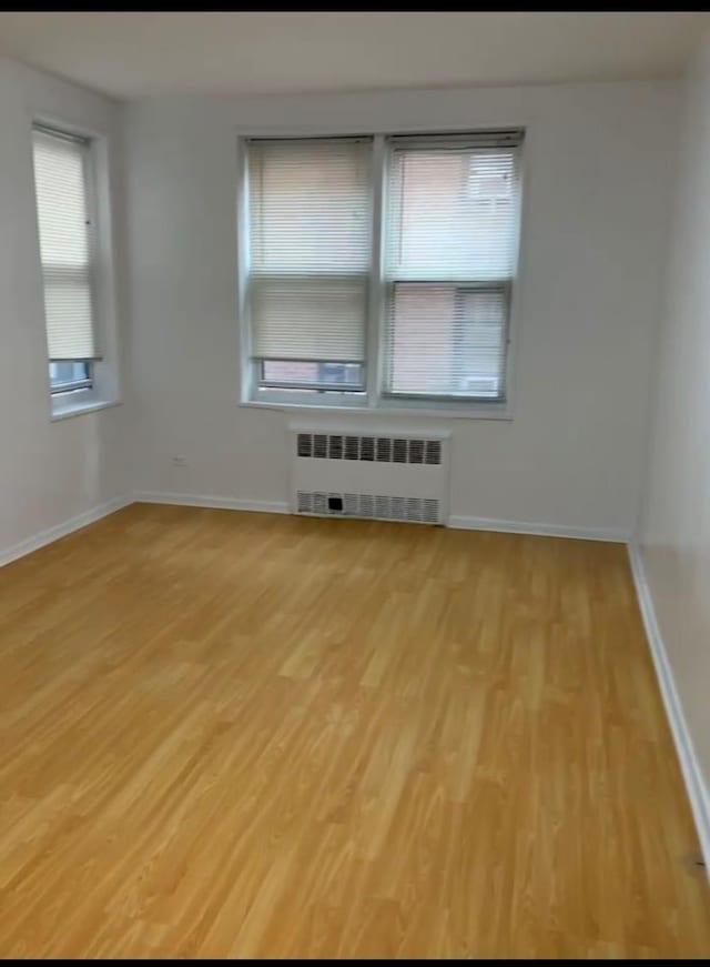 42-40 Bowne St Unit 3L, Flushing, NY 11355 - unfurnished room with radiator, light wood-type flooring, and baseboards