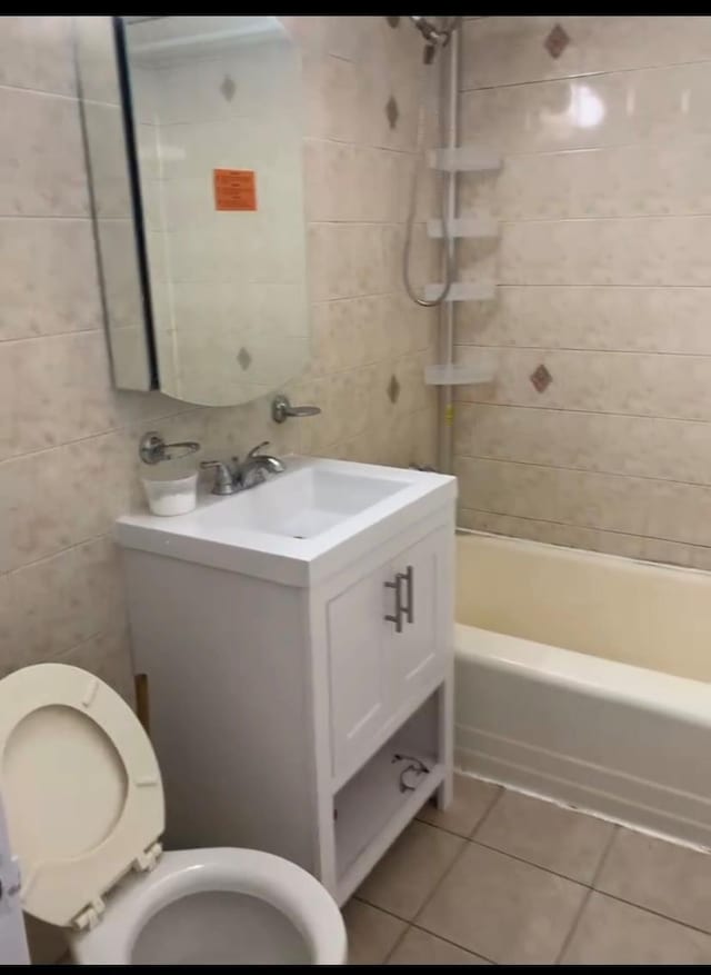 42-40 Bowne St Unit 3L, Flushing, NY 11355 - bathroom with tile patterned floors, vanity, tile walls, toilet, and bathing tub / shower combination