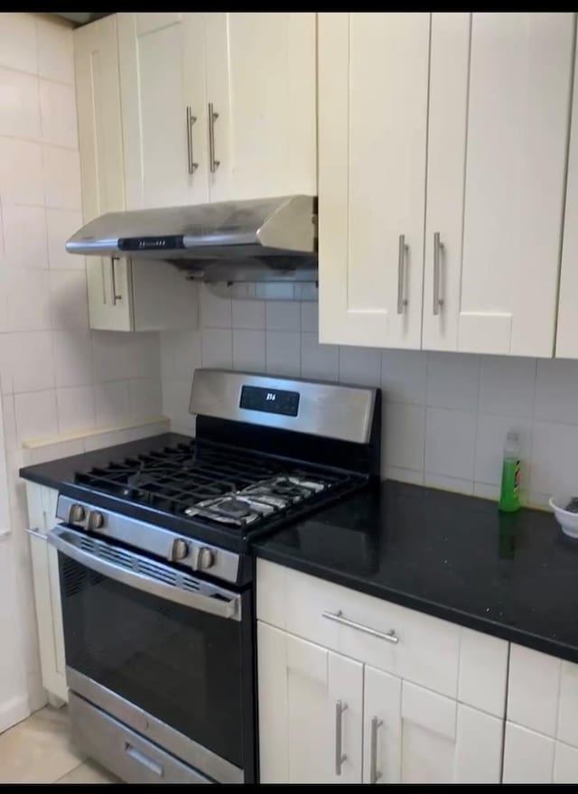 42-40 Bowne St Unit 3L, Flushing, NY 11355 - kitchen with stainless steel gas stove, under cabinet range hood, tasteful backsplash, and white cabinetry