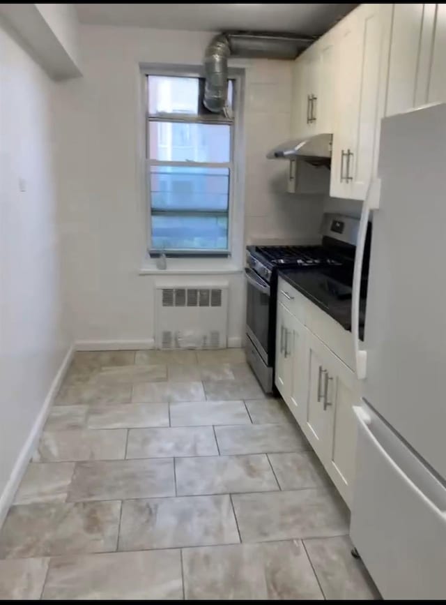 42-40 Bowne St Unit 3L, Flushing, NY 11355 - kitchen with freestanding refrigerator, stainless steel gas range, radiator, under cabinet range hood, and white cabinetry