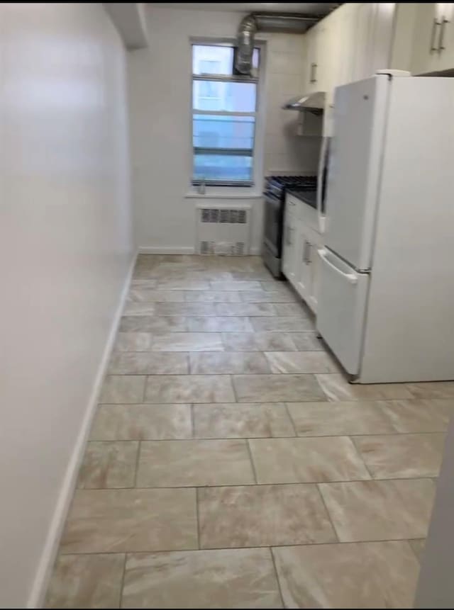 42-40 Bowne St Unit 3L, Flushing, NY 11355 - kitchen featuring freestanding refrigerator, radiator heating unit, stainless steel range with gas stovetop, range hood, and baseboards