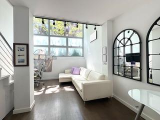living area featuring stairway, baseboards, dark wood-style floors, and track lighting