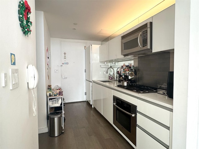 425 E 13th St Unit 1J, New York Manhattan, NY 10009 - kitchen featuring appliances with stainless steel finishes, a sink, light countertops, white cabinetry, and tasteful backsplash
