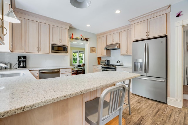 4 Oak St, Cold Spring, NY 10516 - kitchen with appliances with stainless steel finishes, a sink, under cabinet range hood, a peninsula, and backsplash
