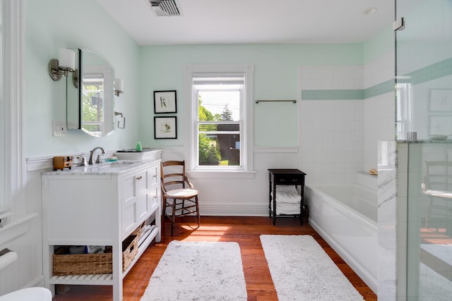 4 Oak St, Cold Spring, NY 10516 - bathroom featuring healthy amount of natural light, wood finished floors, a shower with door, vanity, and a wainscoted wall