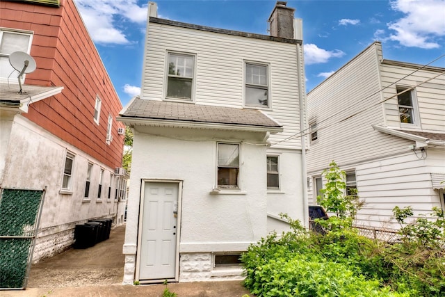 1804 New York Ave, Brooklyn, NY 11210 - back of house with roof with shingles, a chimney, and stucco siding