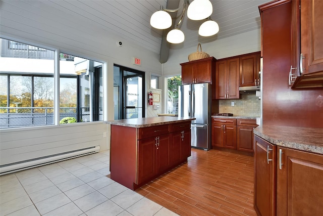 300 High Point Dr Unit 313, Hartsdale, NY 10530 - kitchen with freestanding refrigerator, tasteful backsplash, baseboard heating, a center island, and under cabinet range hood