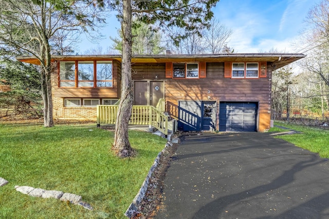 split foyer home with asphalt driveway, a front yard, and a garage