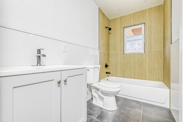 bathroom with tile walls, bathtub / shower combination, toilet, tile patterned flooring, and vanity