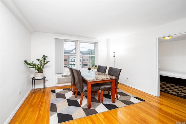 dining space featuring wood finished floors, baseboards, and cooling unit