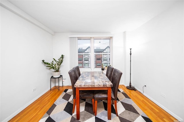 dining room featuring light wood finished floors and baseboards