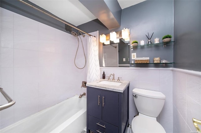 bathroom featuring shower / bathtub combination with curtain, toilet, vanity, tile walls, and a wainscoted wall