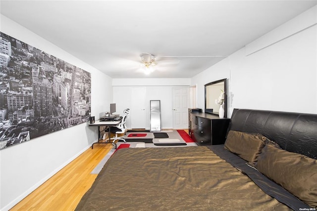 bedroom with wood finished floors, a desk, baseboards, and ceiling fan