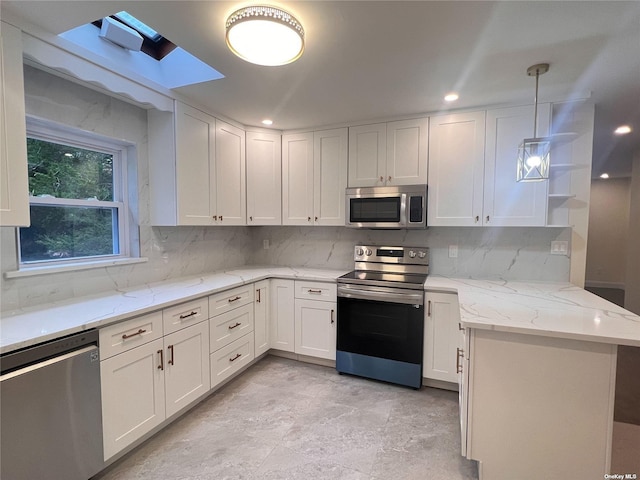 332 Browns Rd, Nesconset, NY 11767 - kitchen with stainless steel appliances, white cabinetry, decorative backsplash, and a peninsula