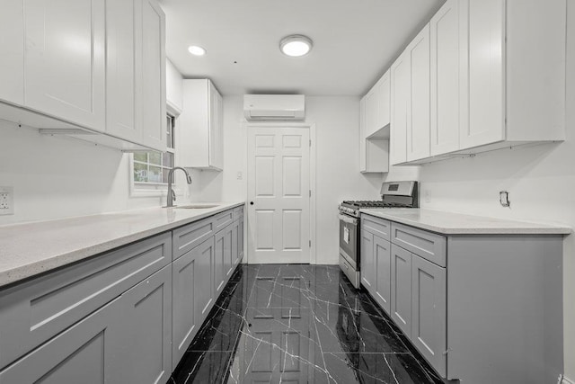 166-03 69th Ave, Fresh Meadows, NY 11366 - kitchen with stainless steel gas stove, a sink, a wall mounted AC, and gray cabinetry