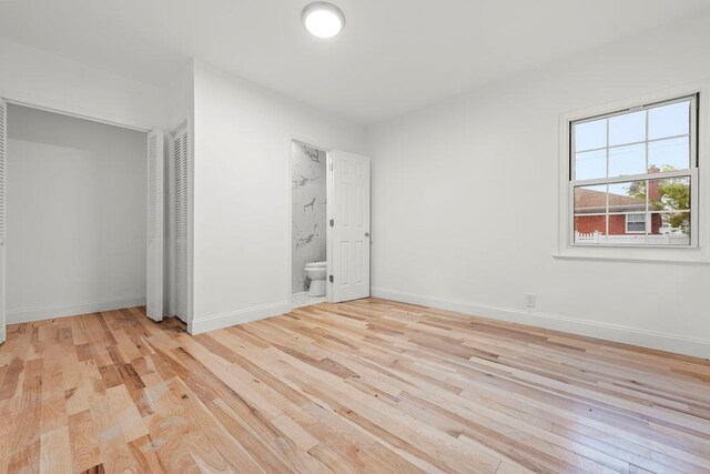 166-03 69th Ave, Fresh Meadows, NY 11366 - unfurnished bedroom featuring light wood-type flooring, baseboards, ensuite bath, and a closet